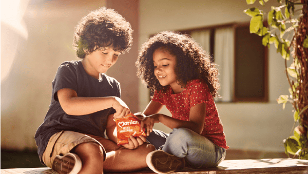 Two children eating Marilan cookies